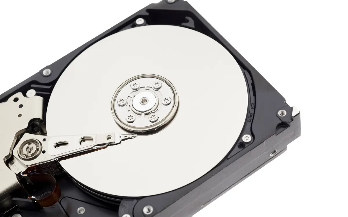 Open hard disk drive showing its platter and read arm
