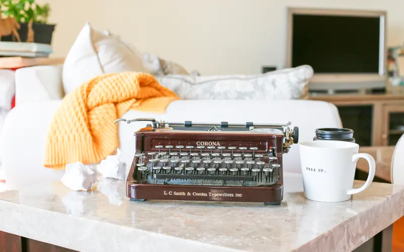 Vintage typewriter on a desk next to a coffee mug