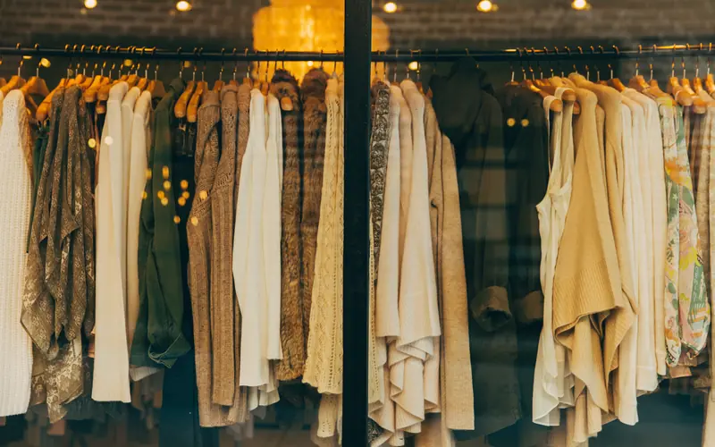 Rack of neutral-toned clothes hanging in a shop