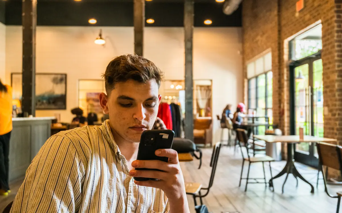 Young man looking at his smartphone in a café
