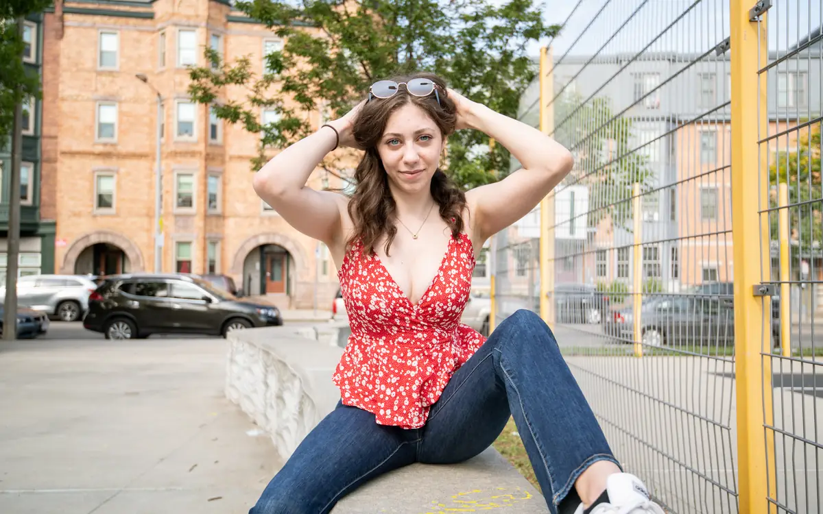 Young woman posing for an outfit photo on a city street