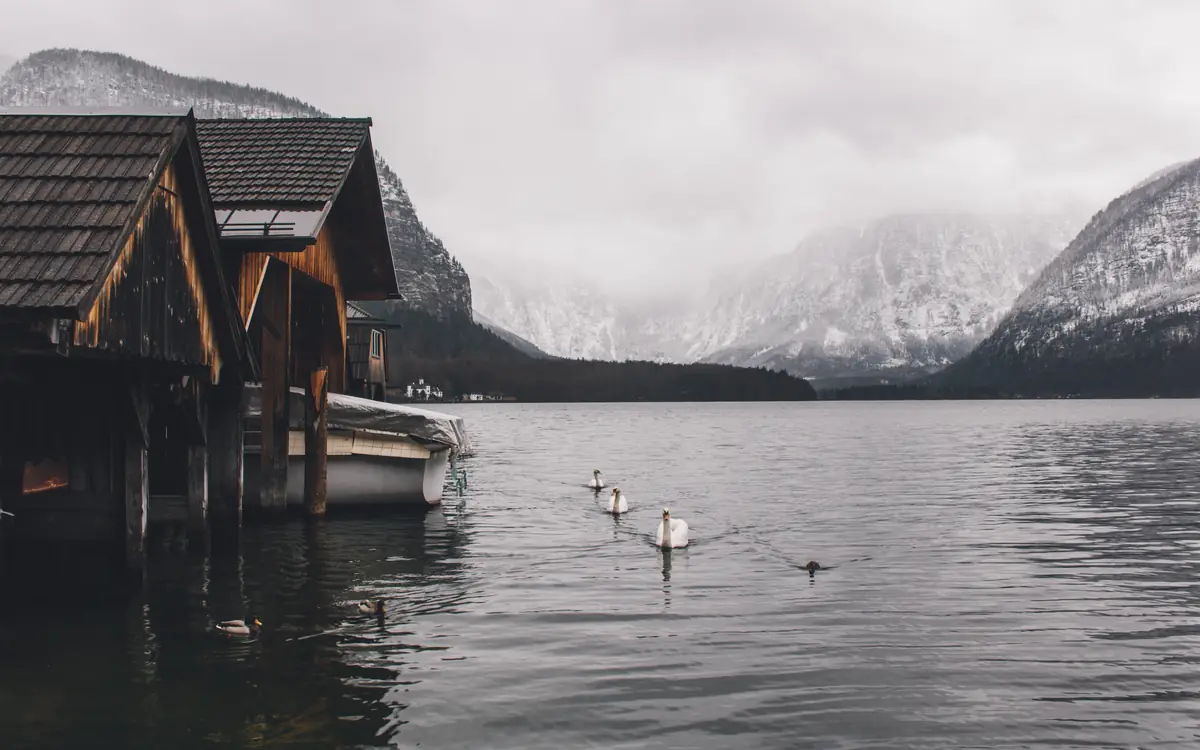 Wooden boathouses beside a calm mountain lake