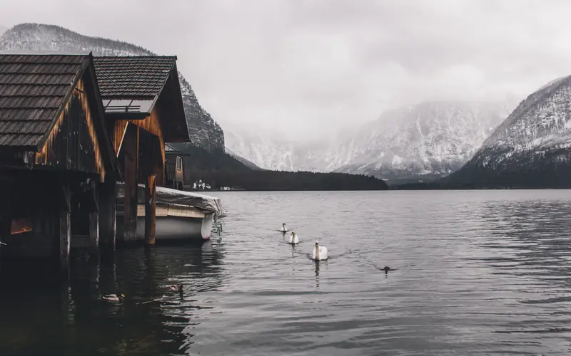 Wooden boathouses beside a calm mountain lake