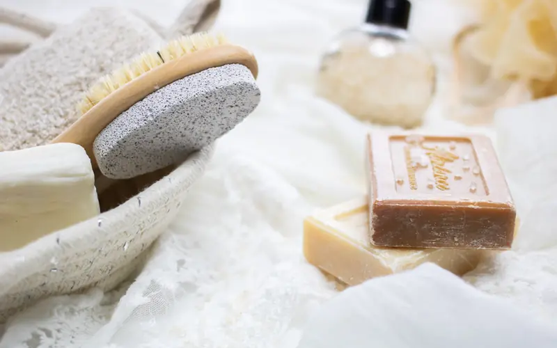 Natural soap bars and bath products on soft white fabric
