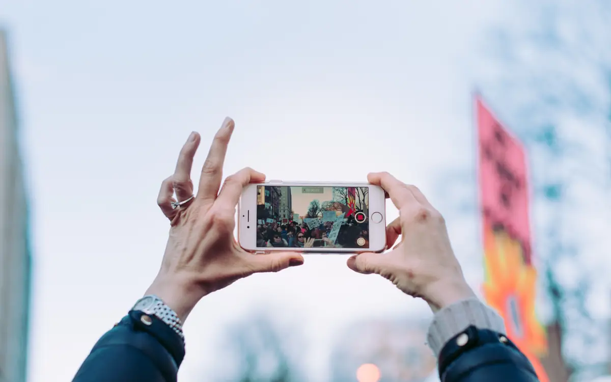 Hands holding a smartphone to photograph a product